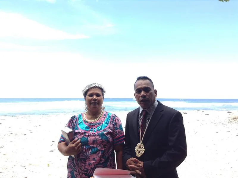 Pastor Nickson Alee and his wife on the shoreline in Kailua-Kona, dressed for a Sunday service.