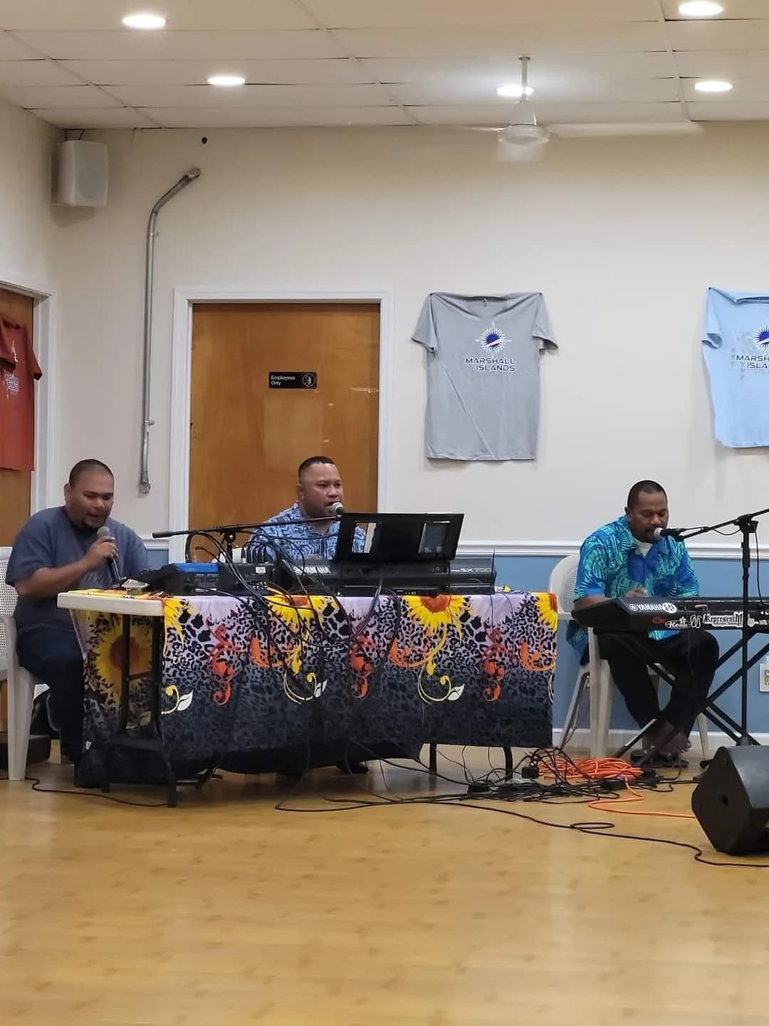 The worship team setting up keyboard and sound equipment in the church hall before a service.